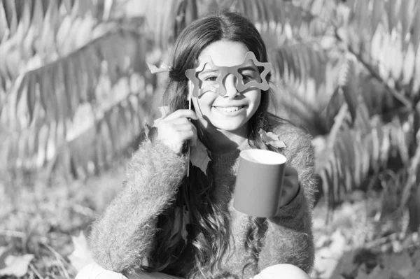 Aint it funny. I love smell of autumn leaves in morning. Happy little child hold coffee cup on autumn morning. Small girl drink morning coffee or tea. Good morning fun