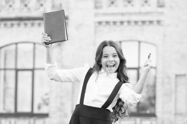 Pase la prueba con éxito. Niña estudiante de escuela. Concepto de educación escolar. Día del conocimiento. Aprender el idioma. Los mejores libros de texto para aprender en casa. Enganchado al aprendizaje. Lindo niño sonriente hold book — Foto de Stock