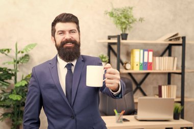 Kahve içmek rahatlatıcı bir mola. Patron enerji içeceğini seviyor. Başarılı insanlar kahve içer. Kafein bağımlısı. Güne kahveyle başla. Adam sakallı iş adamı kahve fincanı standının arkasında duruyor.