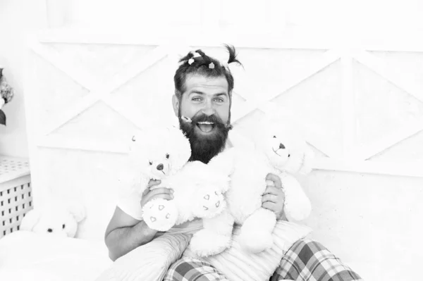 髭を生やした男が熊のおもちゃで遊ぶ。幸せなお父さんリラックスベッドルーム。面白い髪型の父親。クソヒップスターはベッドでリラックス。一日中ベッドにいて家でリラックスする時間だ幸せな父親だ遊びにインスパイアされ — ストック写真