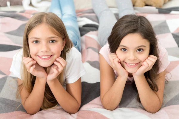 Liberta o teu sorriso. Meninas sorriem relaxando na cama. Crianças felizes a sorrir. Cuidados dentários. Odontologia para crianças. Manter os dentes brancos e limpos. Sorria um sorriso feliz — Fotografia de Stock