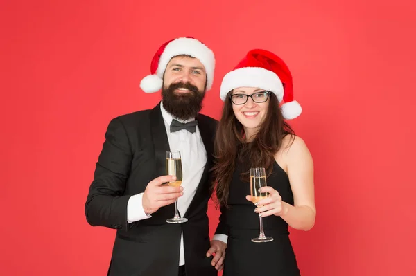 Χριστουγεννιάτικο πάρτι. Το ερωτευμένο ζευγάρι γιορτάζει την Πρωτοχρονιά. Σμόκιν με γυναίκα με καπέλο Άι Βασίλη. Καλά Χριστούγεννα και ζήτω σε όλους. Επιχειρηματίας και κορίτσι πίνουν σαμπάνια. Χριστουγεννιάτικο πάρτι — Φωτογραφία Αρχείου
