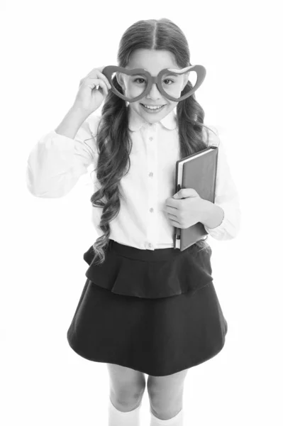 Liebenswerter Bücherwurm. Schulmädchen herzförmige Brille weißen Hintergrund. Kind Mädchen Schuluniform halten Buch. Smart-Kids-Konzept. Verliebt in Bildung. Schulverein. Kinder lernen gern. Schulprojekt — Stockfoto