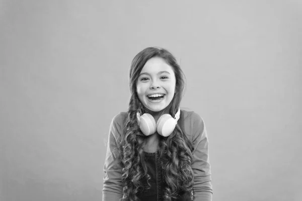 Dérive dans la musique. Joyeux petit DJ sur fond bleu. Jolie fille souriant avec casque DJ. Petit enfant utilisant un casque sans fil pour DJ disco. Adorable enfant appréciant DJ tune jouer à la radio — Photo