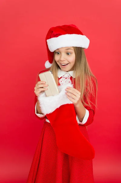 Su primer celular. La chica feliz recibió el teléfono para Navidad. Conseguir el teléfono móvil como regalo. Teléfono de la media navideña. Feliz año nuevo. Permanecer móvil en temporada de vacaciones —  Fotos de Stock