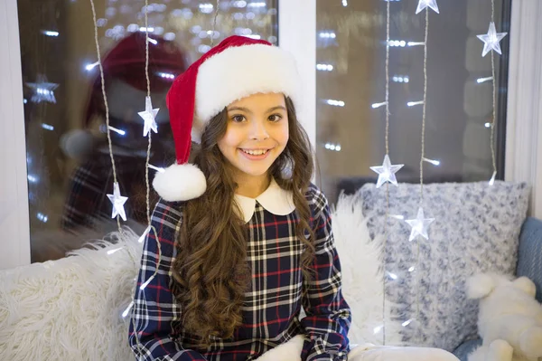 Feeling jolly. Happy child celebrate xmas and new year. Girl child smile in New year dress style. Little child with Santa look. Small child on Christmas eve. Festive holidays. Holiday celebration