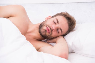 Her gece yeteri kadar uyuyorum. Sağlık hizmeti konsepti. Uykudan uyanma döngüsünü sirkadyan ritmi düzenler. Yatakta tıraş edilmemiş yakışıklı bir adam. Bahşişler daha iyi uyuyor. Sakallı adam yastıkta dinleniyor. Yumuşak yastık