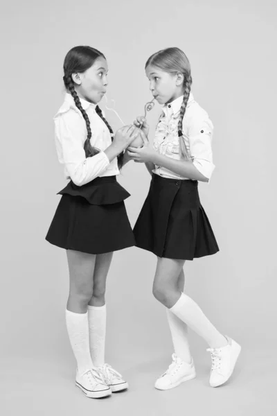 Schoolgirls sharing lunch. Healthy food. Vital habits. Fruits glucose energy source. School lunch. Vitamin nutrition. Fresh fruit school. Girls kids school uniform drinking orange fruit fresh juice — Stock Photo, Image