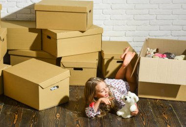 Çalıştığın ve oynadığın yerde yaşa. Yeni bir yaşam alanı satın almak. Oyuncağı olan mutlu küçük bir kız. Karton kutular yeni eve taşınıyor. Yeni evimizde oynuyoruz. Yeni daire. Mutlu çocuk karton kutu