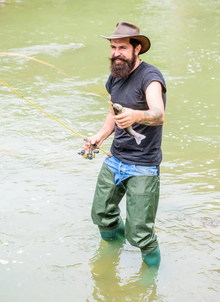 Big Game Sport Fishing. summer weekend. Fly fishing. fisherman show fishing technique use rod. hobby and sport activity. Happy bearded fisher in water. mature man fly fishing. man catching fish