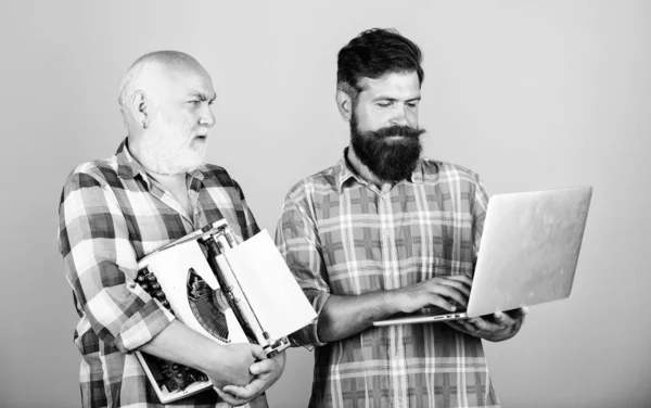 master service. youth vs old age. business approach. father and son. family generation. retro typewriter vs laptop. New technology. technology battle. Modern life. two bearded men. Vintage typewriter