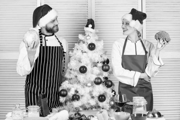 Concept de recette de Noël. L'ingrédient secret est l'amour. Couple préparant un repas sain ensemble pour le dîner de Noël. Cuisiner le repas de Noël. Chapeau homme et femme chef tablier santa près de l'arbre de Noël — Photo