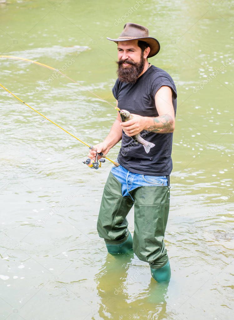 Big Game Sport Fishing. summer weekend. Fly fishing. fisherman show fishing technique use rod. hobby and sport activity. Happy bearded fisher in water. mature man fly fishing. man catching fish