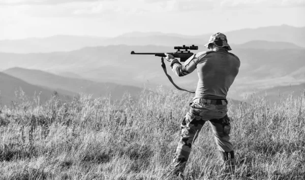 ナイスショット陸軍ハンターはライフルを持ってるハンター山の風景の背景。フォーカスと集中力経験豊富なハンター。武器を持った男の軍服残忍な戦士狩猟用ライフル — ストック写真