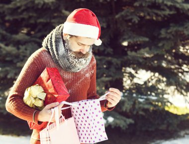Yakışıklı Noel Baba hediyeleri açar.