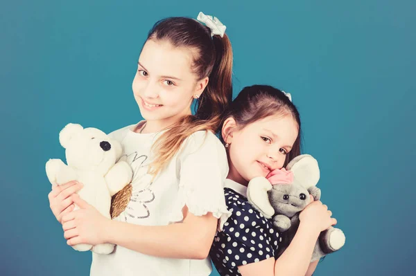 Childhood concept. Kids adorable cute girls play with soft toys. Happy childhood. Child care. Excellence in early childhood education. Sisters or best friends play with toys. Sweet childhood