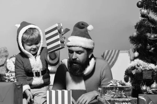 Kerstmis familie opent cadeautjes op blauwe achtergrond — Stockfoto