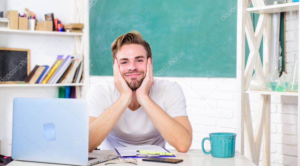 tired student man in classroom with tea cup. man make note and drink coffee. modern education concept. college life. school teacher use laptop and smartphone. back to school. Working day morning