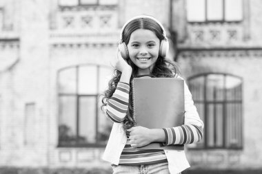 Öğrenme için dijital teknolojiler. Schoolgirl çalışma kitapları ve kulaklık tutun. Eğitim için teknolojiler. Modern teknolojiler. E-öğrenme ve modern yöntemler. Uzaktan eğitim. Dinleme okulu kitabı