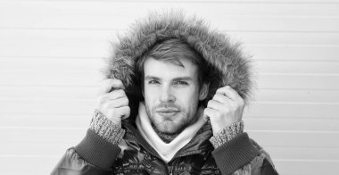 Sıcak tut. Rahat kış giyim. Kış şık erkek giyim. Adam hipster giyim sıcak ceket kürk sarı arka plana sahip sakallı. Adam kukuleta ile sıcak ceket giymek. Sıcak giysiler içinde rahat hissediyorum