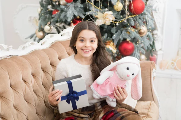 Sincere congratulations. csmall girl love her bunny. best christmas toy gift. heerful kid find gifts at christmas tree. feeling cosy at home. happy new year. cheer and joy. xmas presents at kid shop — Stock Photo, Image