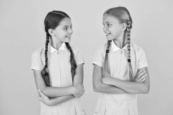 Gelukkige kindertijd. brunette en blond haar. Sisterhood concept. Beste vrienden. vintage stijl. kleine meisjes in retro uniform. Old school mode. terug naar school. gelukkige schoonheid met pigtails. persoonlijke stijl — Stockfoto