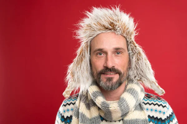 Hipster Mode Winteraccessoires. Ältere, gut aussehende Hipster mit Bart und Schnurrbart tragen gerne ungewöhnliche Sachen. in seinem eigenen Stil. Mann bärtiger Hipster trägt Pelzmütze gestreiften Schal und Strickpullover — Stockfoto