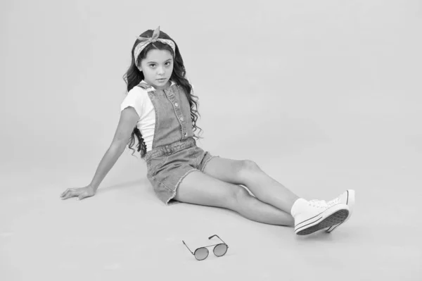 Wenig Fashionista. Unbeschwerte glückliche Kindheit. Moderne Kleidung für Teenager. Nettes kleines Mädchen in Kindermode. Modeaccessoires. Sommerliches Outfit-Konzept. Mädchen mit langen lockigen Haaren sitzen entspannt. Modetrend — Stockfoto