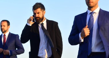 Lider 'in cep telefonu var. Mimarlar kurulu şık takımlar giyer.