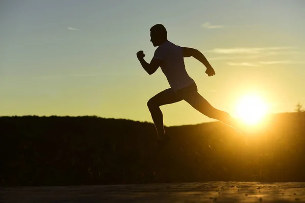 Esportista correndo à noite pegando o sol — Fotografia de Stock