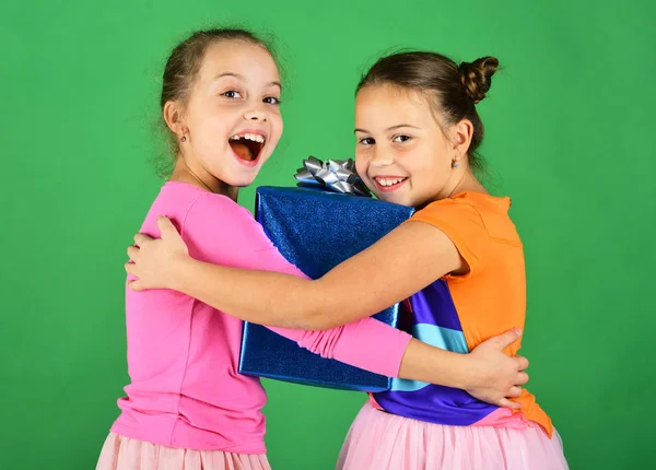 Kinderen knuffelen blauw cadeau voor Kerstmis. Verjaardagsverrassing concept. — Stockfoto