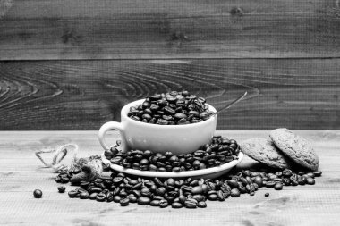 Fincan tam kahve kahverengi kavrulmuş fasulye mavi ahşap arka plan. Kafe içecekler menüsü. Yulaf kurabiyesi ile kahve molası. Taze kavrulmuş kahve fasulyesi. Kafein konsepti. İlham ve enerji ücreti için içecek