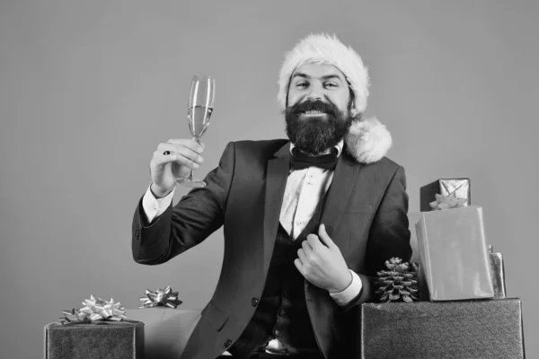 Homem com barba segura champanhe no fundo vermelho. — Fotografia de Stock