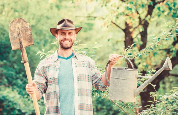Eco farm. Harvest. sexy farmer hold shovel and watering can. muscular ranch man in cowboy hat. farming and agriculture cultivation. Garden equipment. happy earth day. Eco living. Flowers need my care — Stock Photo, Image