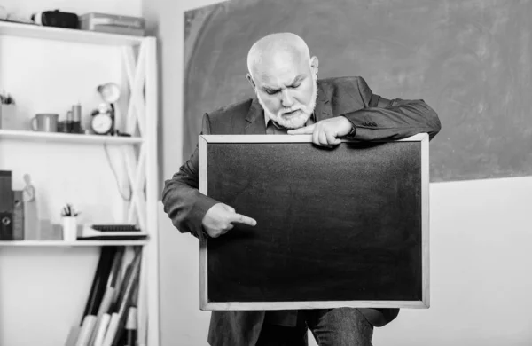 Presentazione. insegnante senior con lavagna vuota. le informazioni sono qui. esame e risultati di laurea. posto per spazio di copia. Maturo insegnante uomo tenere gesso bordo. Torniamo a scuola. Concetto educativo — Foto Stock