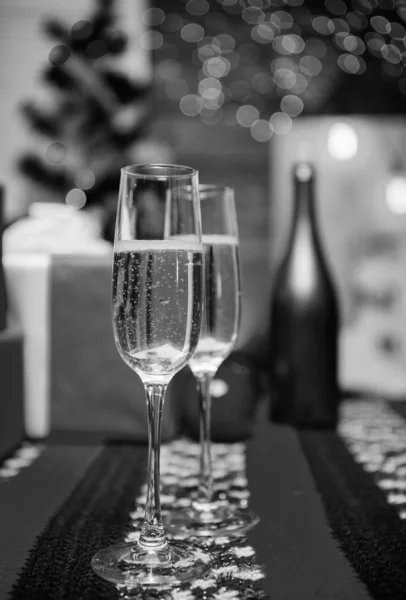 Gelukkig nieuw jaar en merry christmas. Glas champagne close-up. Champagne paar glazen. Glas gevuld mousserende wijn of champagne in de buurt van geschenkdozen. Cheers concept. Nieuwjaar traditionele kenmerk — Stockfoto