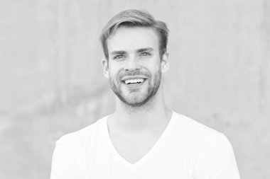 Seçimin gururun. Gülümseyen maço adam. Yaz erkek modası. Öğrenci traşsız, stil sahibi saç stili. Sakallı adam gündelik tarzda. Erkek çekiciliğinin portresi. Genç, seksi, gri arka plan