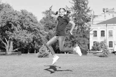 Sürücü dansçılığı mükemmelliği. Küçük dansçı yeşil çimlerde zıpladı. Tatlı kız dansçı enerjik dans ediyor. Kulaklıkla müzik çalan sevimli küçük dansçı.
