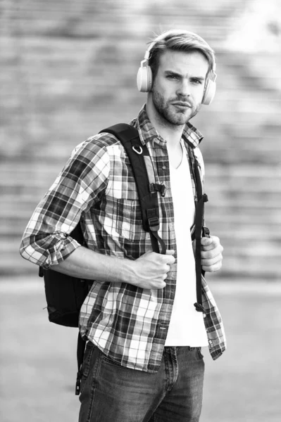 Casque et sac à dos pour étudiants universitaires. Éducation en ligne. Concept de livre audio. Il étudie à l'université. étudiant e apprentissage. la vie scolaire. Écoutez de la musique. Jeunesse moderne et numérique. homme à la mode — Photo