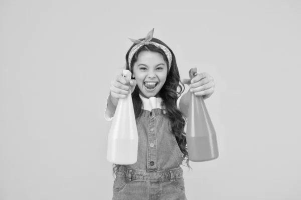 Mijn huis ruimde mijn weg op. Gelukkig klein meisje schoon huis op gele achtergrond. Kleine huishoudster houdt spuitflessen vast. Thuis in de hand van schoonmaak service. Huishoudelijke taken — Stockfoto