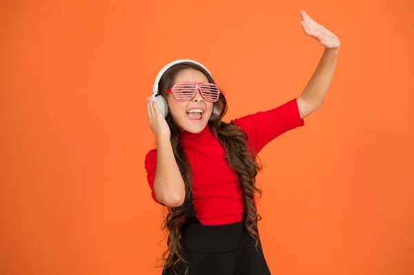 Tanz mit Lieblingslied. Schulfunk-DJ. kleines fröhliches Mädchen hört Musik über Kopfhörer. Lustiges Kind mit Parteibrille. Zeit für Spaß. moderne Kinder genießen Musik. sich stilvoll und selbstbewusst fühlen — Stockfoto