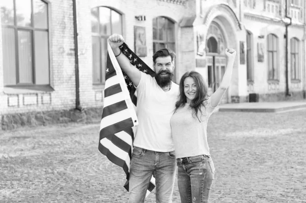 Amerikaans burgerschap is een zeer kostbaar bezit. Bearded man en sensuele vrouw houden Amerikaanse vlag op 4 juli. Amerikaans echtpaar viert Onafhankelijkheidsdag. Leef de Amerikaanse droom — Stockfoto