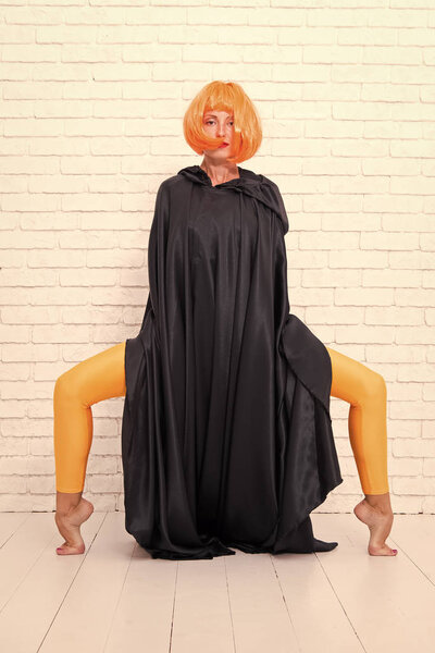 Dancer lifestyle. Enjoyment in motion. Feel your body. Dancing theatre performer. Dancing in cloak. Girl with long fit legs in orange tights dancing. Woman ginger wig performing modern art dance