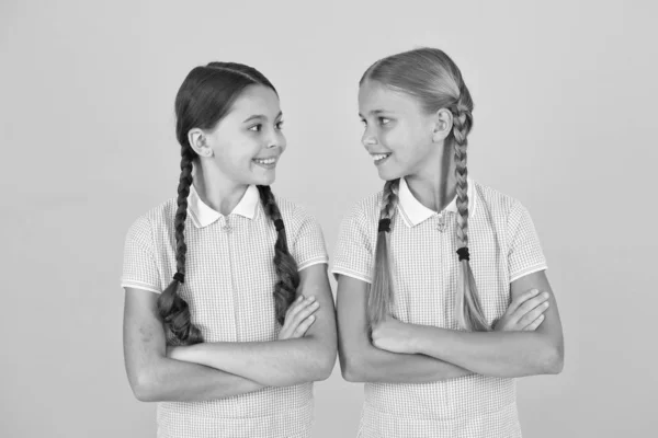 Young and beautiful. brunette and blond hair. sisterhood concept. best friends. vintage style. small girls in retro uniform. old school. back to school. happy beauty with pigtails. happy childhood — Stock Photo, Image