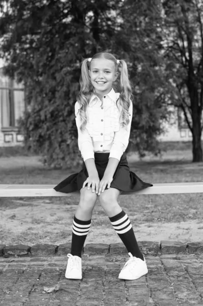 Relajarse en el patio de la escuela. Colegiala perfecta relajándose entre clases. Balance de vida. Estudiante adorable niño en uniforme formal relajante al aire libre. Hora de relajarse y divertirse. Agradables minutos de descanso —  Fotos de Stock