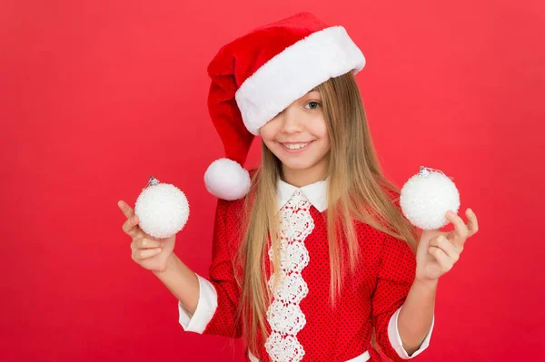 Je suis sur la bonne liste du Père Noël. Joyeux enfant tenir des boules d'arbre de Noël. Petite fille sourire avec le regard du Père Noël. Célébrez Noël et le nouvel an dans le style du Père Noël. La veille de Noël. Fête du Nouvel An. Fête du Père Noël — Photo