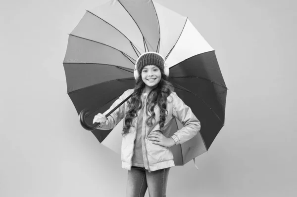 Accessory in case it rains. Small child enjoy music under colorful umbrella rain accessory. Little girl in coat with fashion accessory for rainy autumn season. The perfect accessory to keep her dry