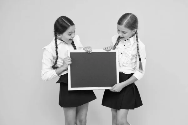 Πρώτα η εκπαίδευση. Μικρά παιδιά που κρατούν λευκό μαυροπίνακα για εκπαίδευση σε κίτρινο φόντο. Υποχρεωτική πρωτοβάθμια σχολική εκπαίδευση. Λήψη επίσημης εκπαίδευσης, αντιγραφή χώρου — Φωτογραφία Αρχείου