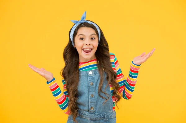 Gelukkige jeugd. retro meisje vrolijk gebaar. Zomervakantie vreugde. kleine kind gele achtergrond. ouderwetse kindermode. klein schoonheidszakdoekje lang haar. vintage stijl. retro mode model — Stockfoto