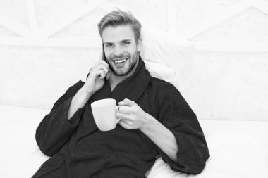 Hipster adam pijama bornoz serbest çalışan evde dinleniyor. Uzaktan çalışma konsepti. Bunu duyduğuma sevindim. Gezici konuşma. Cep telefonu. İletişim cep telefonu. İyi haber konsepti. Günaydın.